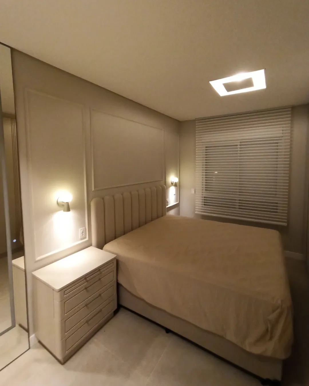 Apresentamos este quarto incrível, com uma cabeceira de cama estofada em linho, arandelas elega